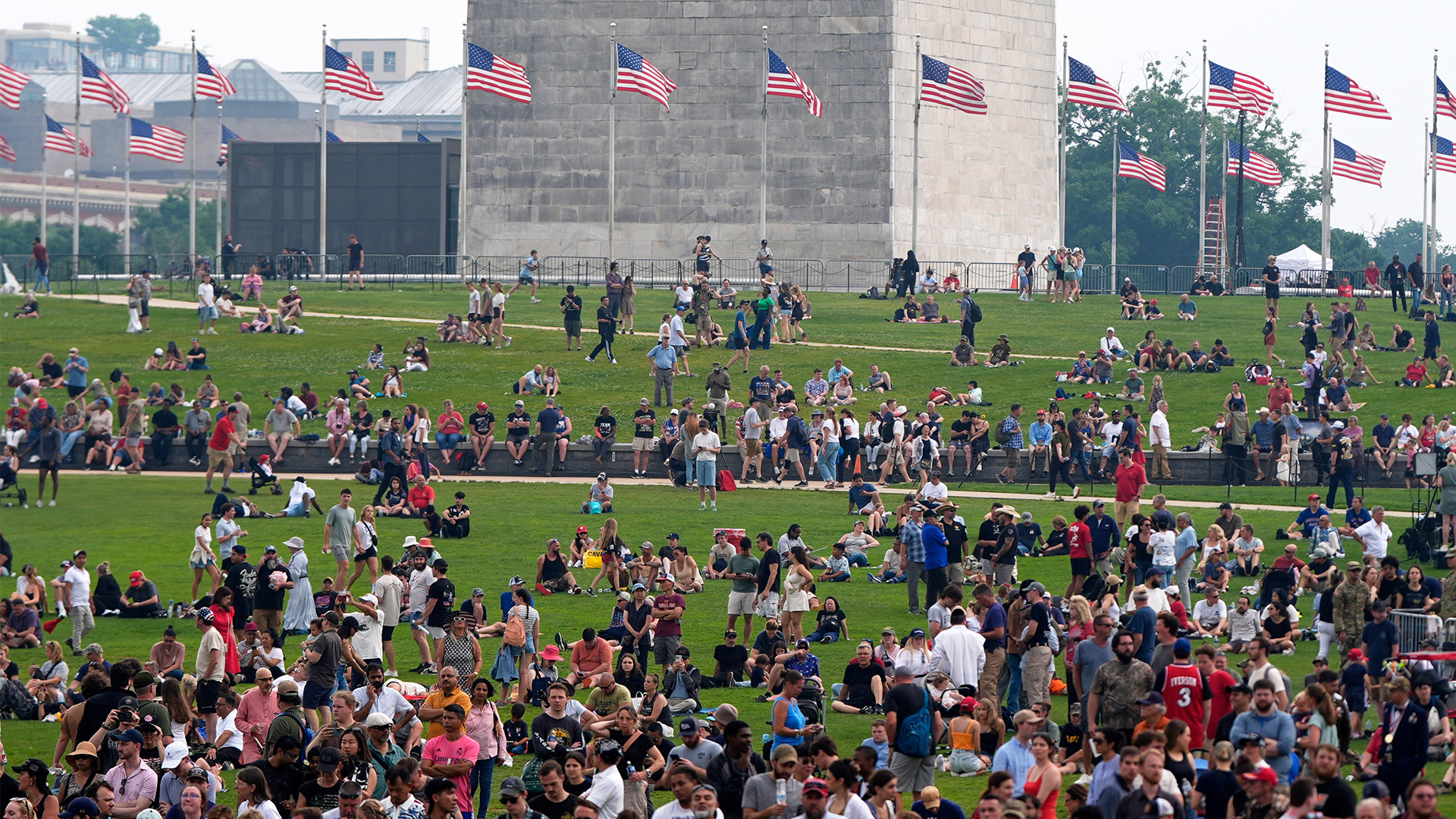 People on the lawn around the Washington Monument as Pres. Trump attends a military parade commemorating the Army's 250th anniversary on June 14, 2025, in Washington.